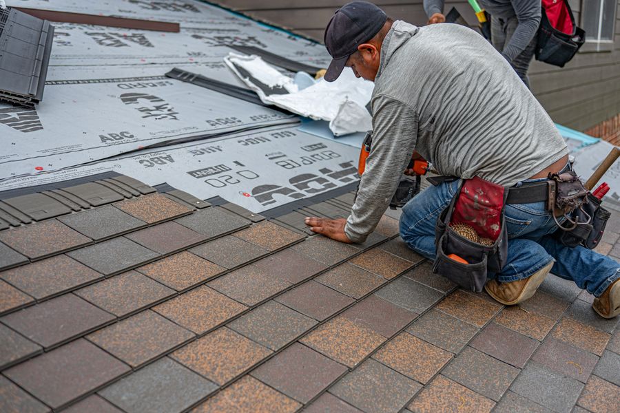 Roofer installing shingles during a roof replacement